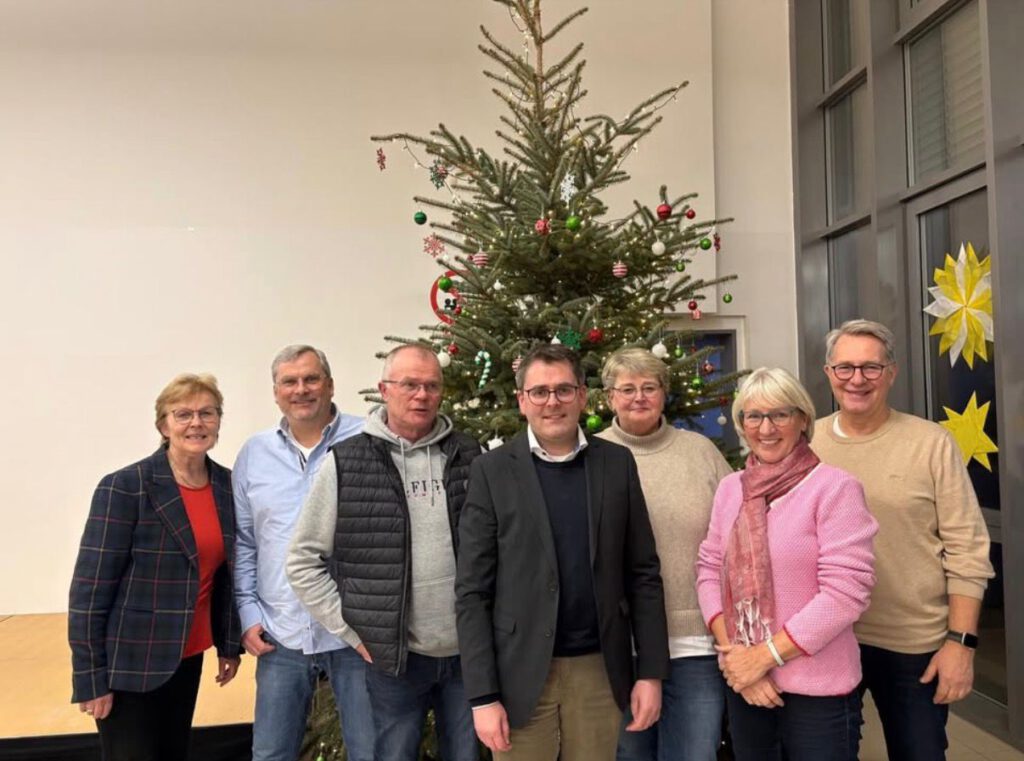 Personengruppe vor einem Weihnachtsbaum